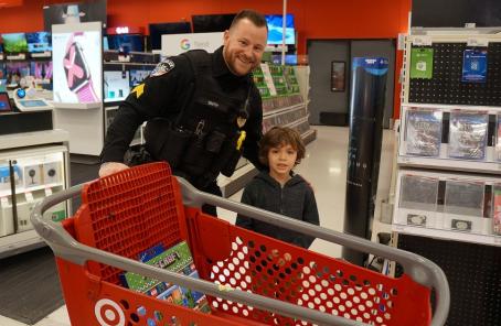 Police officer in Target standing next to cart with a child