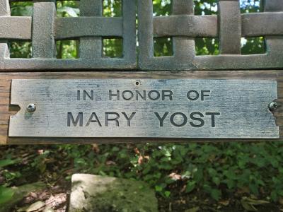 Plaque on bench that reads in honor of Mary Yost