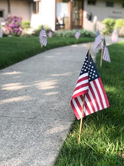 american flags line the sidewalk to the community building 