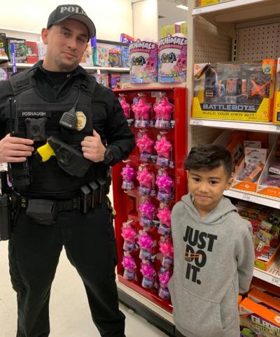 officer and child smile in toy section of store