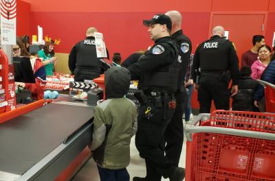 officers wait in check out line with child 