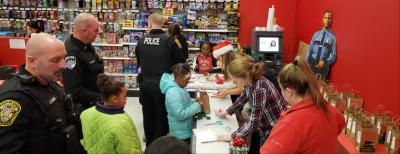 officers wait with children in front of gift wrapping station in store 